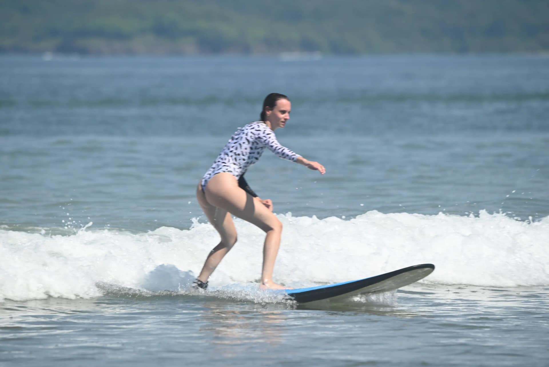Surf school Tamarindo — instructor guiding student on a wave