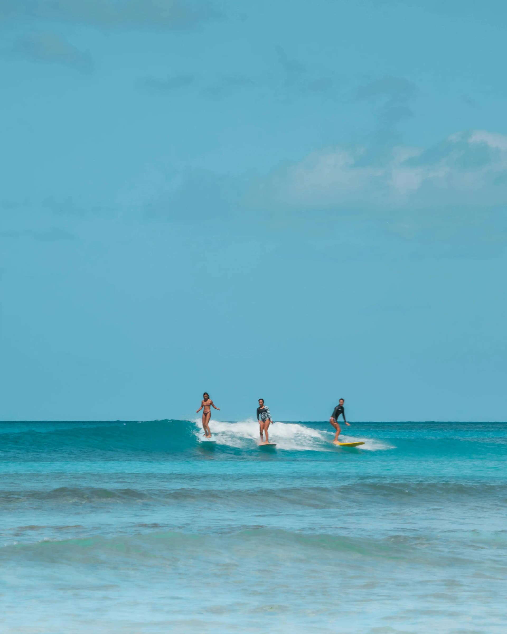 First-time surfer catching a whitewater wave during a beginner lesson in Tamarindo